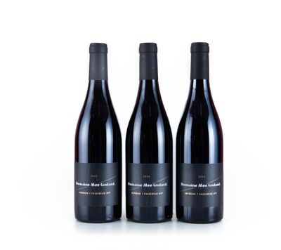 trois bouteilles de vin rouge sont posées côte à côte sur une surface blanche