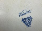 a close up of a blue and white vase with a bird on it
