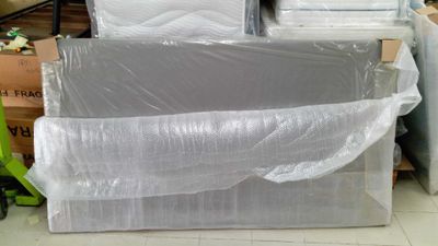 une pile de matelas posée sur une pile de cartons