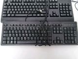 two keyboards sitting next to each other on a table