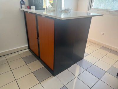 a kitchen island with a counter top in the middle of the room