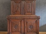 une vieille armoire en bois avec des sculptures et des gravures sur les portes