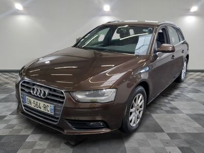 L'Audi marron est garée sur un sol à damier dans un garage.