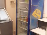 two refrigerators and a table in a room