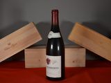 a bottle of wine sitting on a table next to two wooden boxes