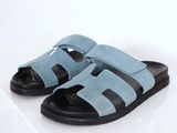 blue sued sandals with black soles on a white surface