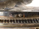 a close up of a silver plate with a clock on it