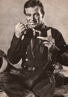 a black and white photo of a man eating a piece of cake