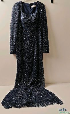 black sequinned dress hanging on a hanger on a wall