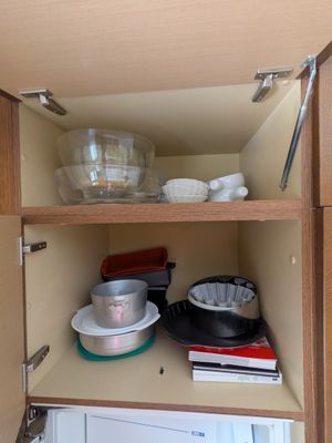 un placard de cuisine contenant de la vaisselle et des casseroles