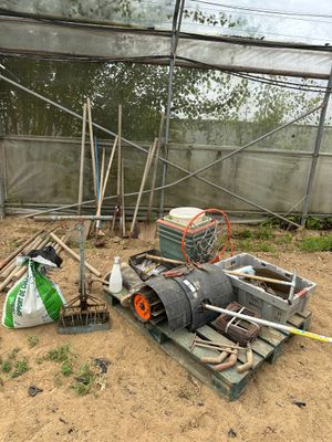 un tas d'ordures dans une serre où se trouvent de nombreux outils