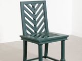 an image of a green chair in a room with a white wall