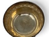 an old silver bowl on a white surface with a white background