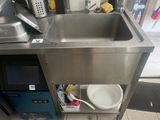 un évier en inox et un micro-ondes dans une cuisine