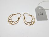 une paire de boucles d'oreilles créoles en or avec une étiquette sur fond blanc