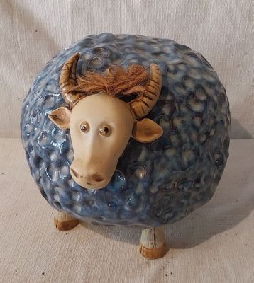un mouton en céramique bleue et blanche avec des cornes sur la tête