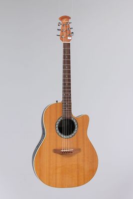 an acoustic guitar hanging on a wall with a white background