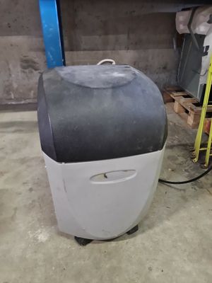 a white and black cooler sitting in a garage