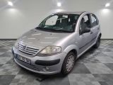a small silver car parked in a room with checkered floor