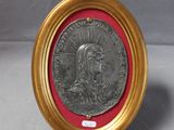 une vieille médaille en argent dans un cadre doré bordé de rouge