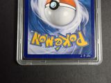 a pokemon card in a plastic case on a table