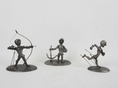 three metal figurines of a man with a bow and arrow