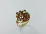gros plan d'une bague en or avec des pierres multicolores