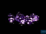 some very pretty purple diamonds on a black surface