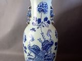 un vase bleu et blanc orné d'un oiseau et de fleurs