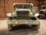 two old military vehicles parked in a garage