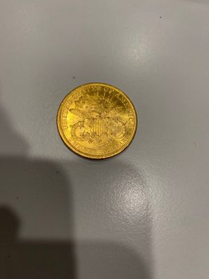 une pièce d'or posée sur une surface blanche