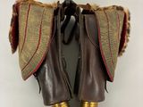 une paire de bottes en cuir marron, doublées de fourrure et ornées de détails dorés