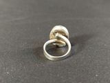a close up of a silver ring on a black surface