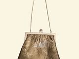 a gold purse with a chain strap hanging from it ' s handle