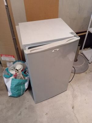 un réfrigérateur blanc posé dans le coin d'une pièce