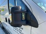 the side view mirror of a white van is shown with a sticker on the side of it
