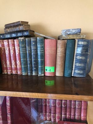 une étagère sur laquelle sont posés de nombreux livres, avec une horloge posée dessus