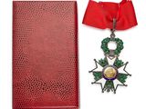 une image représentant un livre rouge orné d'une médaille et d'un ruban rouge