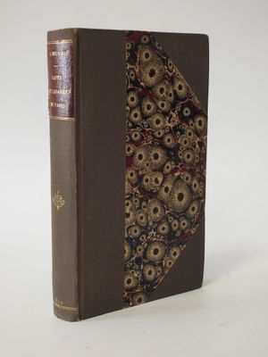 an old book with a decorative cover on a white surface