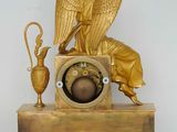 a gold clock with an angel on top of it