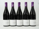 six bottles of wine are lined up in a row on a white surface