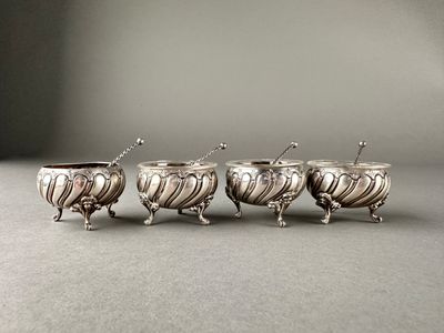 trois tasses en argent, avec des cuillères de chaque côté