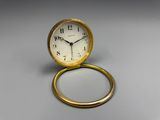 a small clock sitting on top of a gold ring