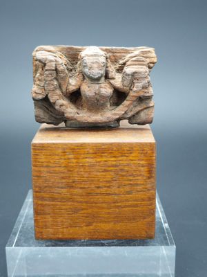 une image représentant une sculpture d'un homme et d'une femme sur un bloc de bois
