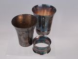 three silver cups sitting on top of a white surface