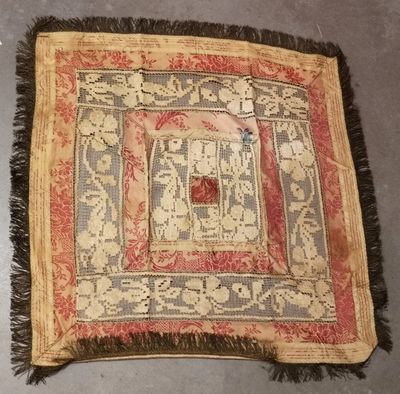 un vieux tapis avec une bordure rouge et des franges, posé sur le sol