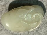 a white stone with a face on it on a gray surface