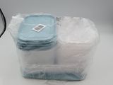 un récipient en plastique rempli d'objets bleus et blancs posé sur une table