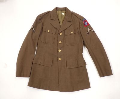 an old military jacket with a patch on the chest and a patch on the shoulder