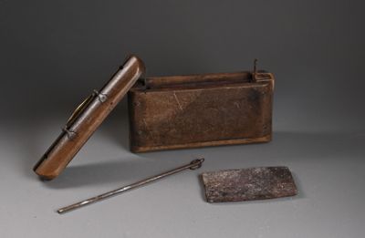 une petite boîte en métal munie d'une poignée en bois et d'une cuillère en métal